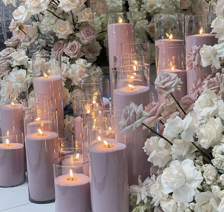 Pink candles with white flowers on a white background